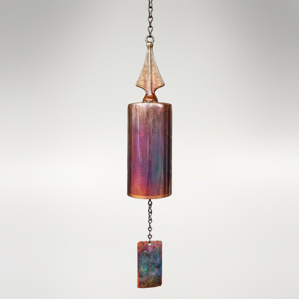 Handcrafted San Geronimo Mission Wind Bell by Lago Luna Metal Art Studio, featuring a cylindrical copper body with a vibrant torched patina in shades of purple, blue, and copper.